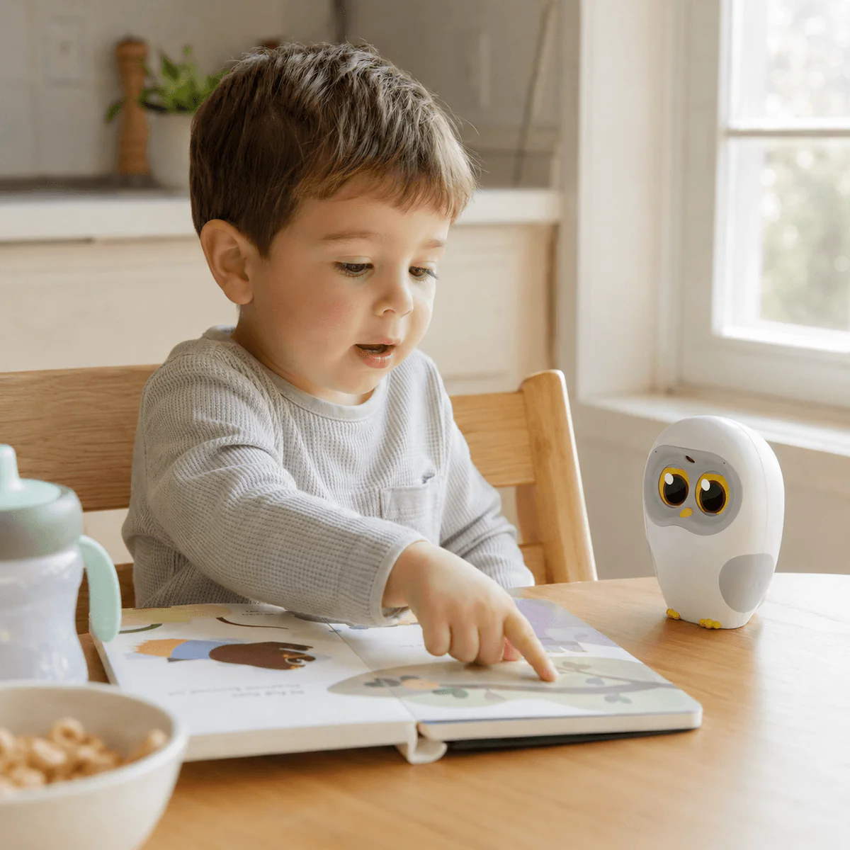 Jason's son at the kitchen table reading a board book with Luka